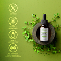 Attuva Oil of Oregano bottle with green leaves on a green background